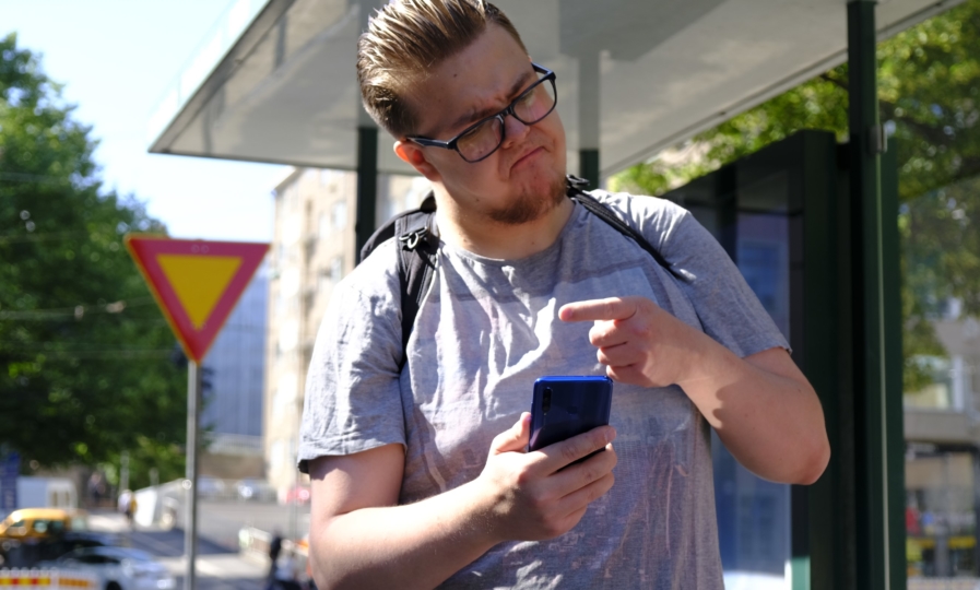 Ihminen osoittaa puhelinta ja näyttää vihaiselta.