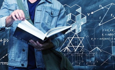 Henkilö pitää kädessään paksua kirjaa. Taustalla liitutaulu, jossa geometrisia kuvioita ja matemaattisia kaavoja.